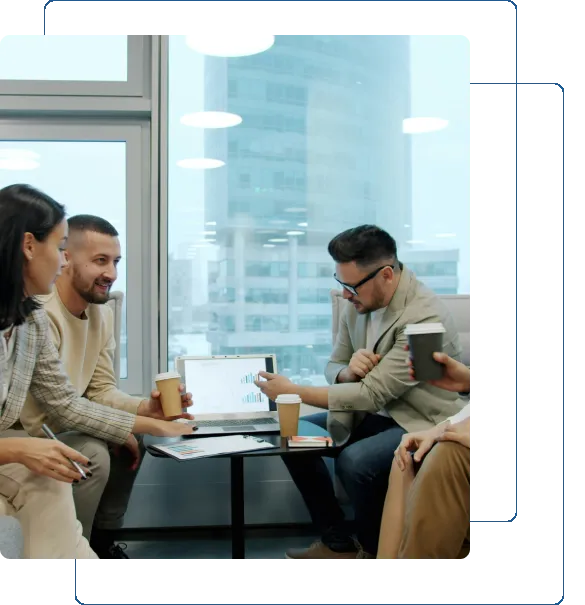 Four people enjoying coffee and conversation in a modern cafe.