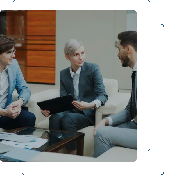 Three professionals engaged in a business meeting conversation.