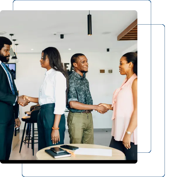 Two pairs of colleagues shaking hands in a modern office setting.