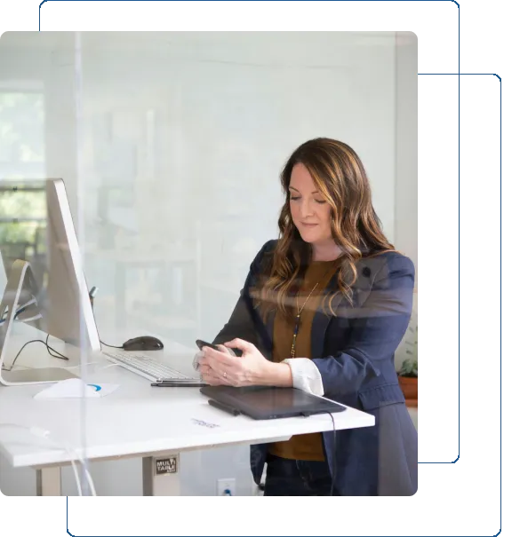 Professional woman working at a modern office desk with a computer.